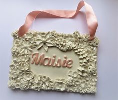 a cake decorated with flowers and the word maisie on it's front side