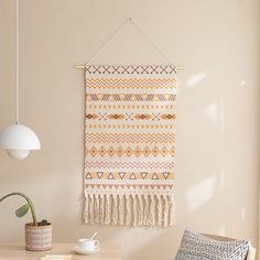 a room with a table, chair and wall hanging