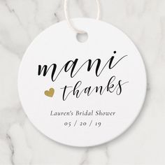 a white ceramic ornament with gold heart on it that says manii thanks