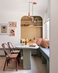 a table with two chairs next to it and some pictures on the wall behind it