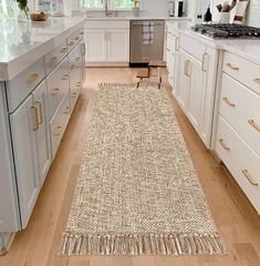 a kitchen with white cabinets and wooden floors