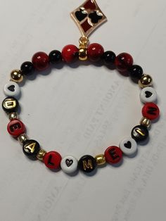 a red, white and black beaded bracelet with the word i love m on it