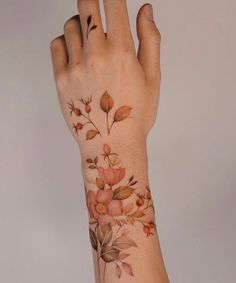 a woman's hand with a flower tattoo on it