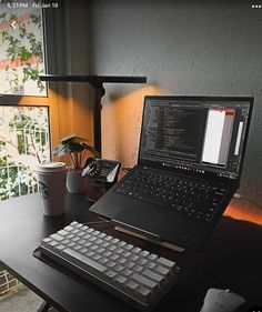 a laptop computer sitting on top of a wooden desk next to a keyboard and mouse