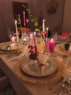 the table is set with candles and plates