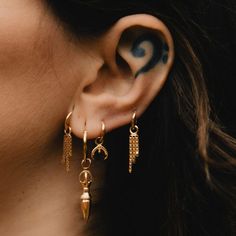 A delicate charm adorned with three chains. Meticulously crafted, this piece seamlessly bridges edge and elegance in helix piercing, making it truly stand out. Design: by NOIR KĀLA Material: 22k Gold Vermeil (3 microns) Pendant size: 5 mm x 22 mm Hoop size: 10 mm Weight: 2 g (pair) Gold Dangle Metal Piercings, Gold Metal Dangle Piercings, Gold Dangle Piercings In Metal, Gold Metal Piercings, Tarnish Resistant Metal Dangle Cartilage Earrings, Dainty Metal Pierced Cartilage Earrings, Dainty Metal Cartilage Earrings, Pierced, Dainty Hoop Jewelry With Dangling Charms, Dainty Metal Cartilage Earrings