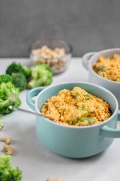 two blue bowls filled with food next to broccoli