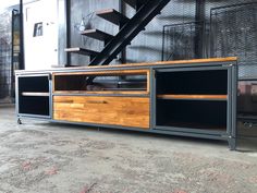 a large entertainment center with drawers and stairs in an industrial setting, on concrete flooring