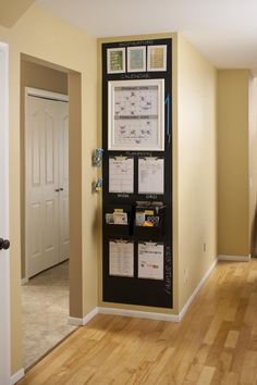 a wall hanging organizer in the corner of a room next to a door with sticky notes on it