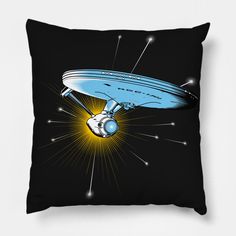 a black pillow with an image of a blue flying saucer on it's side