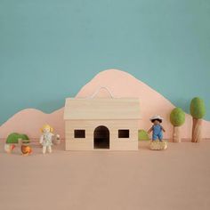 a small toy house with figurines on the floor and in front of it