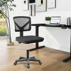 a black office chair sitting in front of a desk with a laptop computer on it