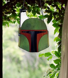 a stained glass star wars helmet hanging from a tree