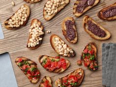 several pieces of bread with different types of food on them sitting on a cutting board