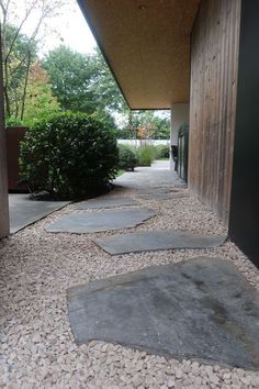 the walkway is lined with stones and gravel, leading to an entrance that leads into a building