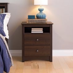 a night stand with two drawers and a lamp next to it on a wooden floor