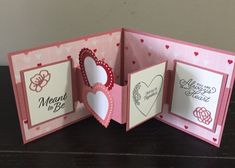 an open pink card with hearts and flowers on the inside is shown in this image