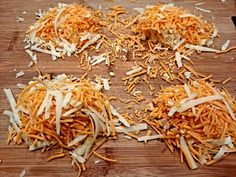 shredded cheese on a wooden cutting board ready to be cut into bite size pieces and serve as toppings