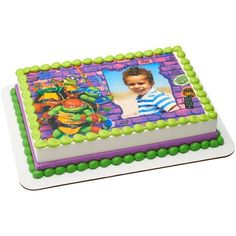 a birthday cake with a teenage mutant photo on the front and green frosting around the edges