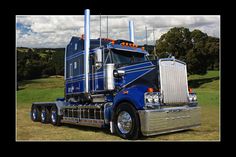 a large blue semi truck parked in a field