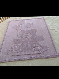 a pink rug with a teddy bear on it sitting on top of a wooden table