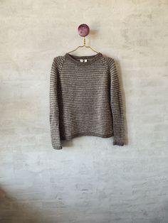 a gray sweater hanging on a white wall