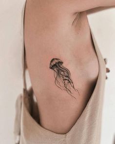 a woman's shoulder with a tattoo of a jellyfish