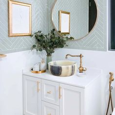 a bathroom with a sink, mirror and plants on the counter in front of it