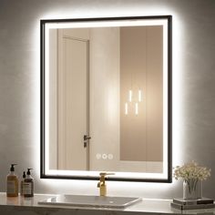 a bathroom sink with a lighted mirror above it