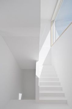 an empty room with white walls and stairs