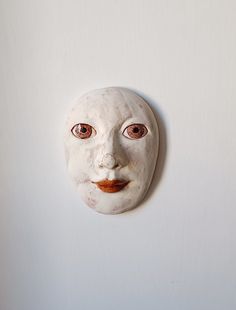 a white mask hanging on the wall