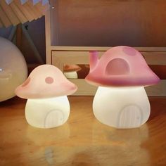 two mushroom shaped lights sitting on top of a wooden table