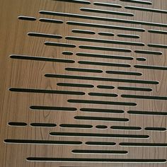 a metal grate with holes in it on a wooden surface