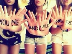 three girls are holding their hands up with words written on the palm of their palms