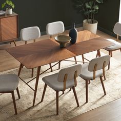 a dining room table with six chairs and a vase on the end shelf in front of it