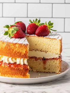 a cake with strawberries on top is cut in half and served on a plate