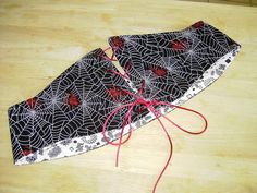 a black and white spider web design on a wooden table with red string attached to it