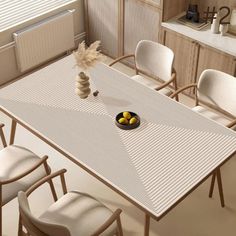 a dining table with four chairs and a bowl of lemons on the table next to it