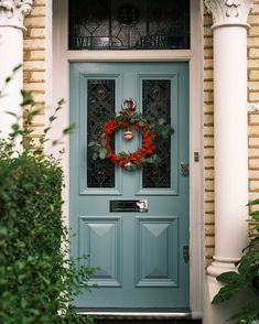 a blue front door with a wreath on it