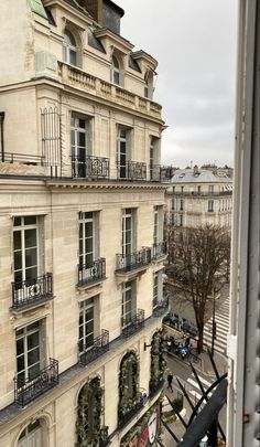 an apartment building with balconies and balcony railings in paris, france on a cloudy day