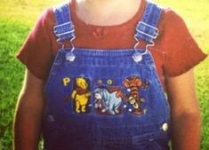 a young child wearing winnie the pooh overalls