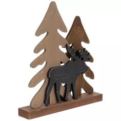 a wooden moose standing next to a pine tree on top of a shelf in front of a white background