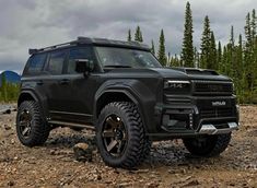 a black suv is parked on some rocks