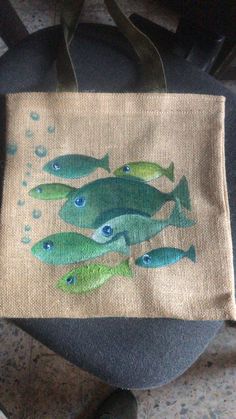 a bag with fish painted on it sitting on a chair