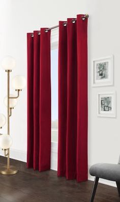 a living room with red curtains and a chair