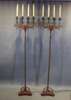 two tall metal candlesticks sitting next to each other