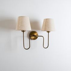 two lamps mounted on the wall next to each other with one light on it's side