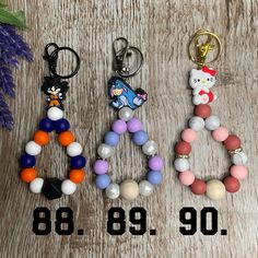 three key chains with beads and charms on them