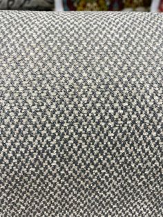 a close up view of a gray and white checkered fabric on a chair with other chairs in the background