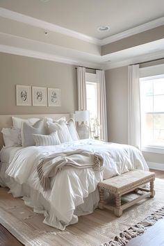 a large white bed sitting in a bedroom next to a window